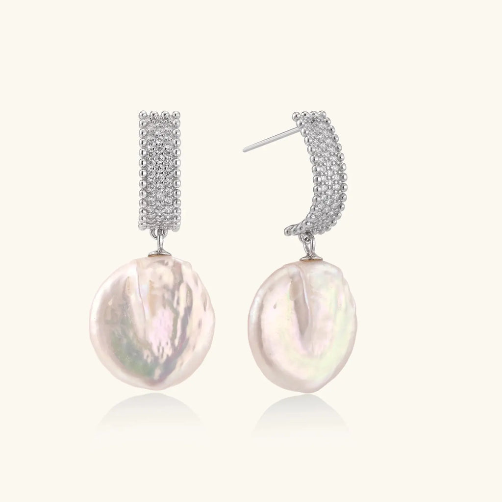 Rhodium-plated silver curved stud with pave stones and baroque pearl drop on white background